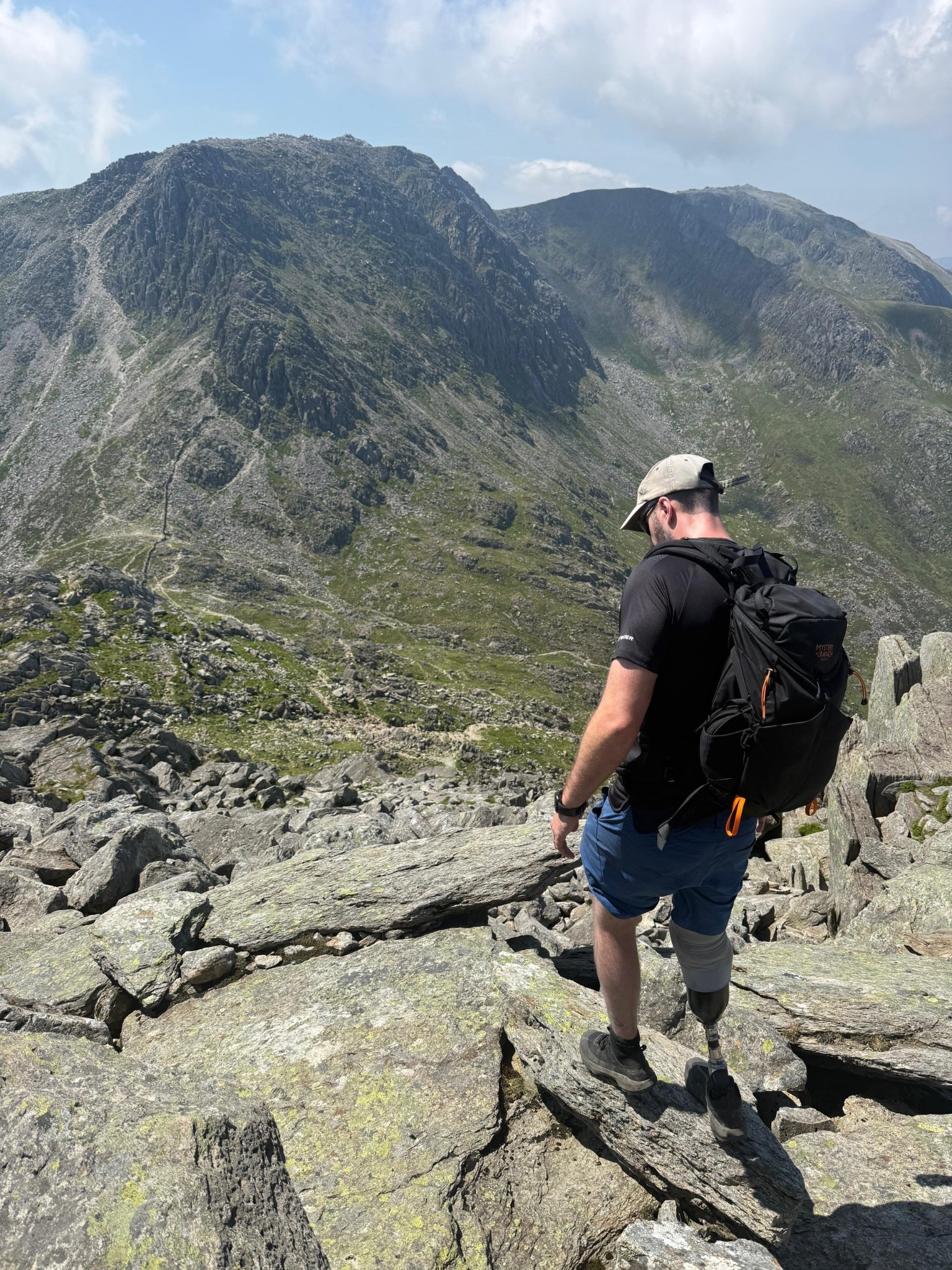 Chay Coulbert descending rocky mountain terrain with his prosthetic leg