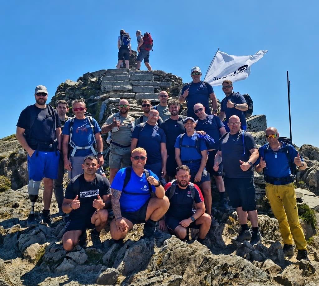 Chay Coulbert with a guided group on a rocky mountain summit